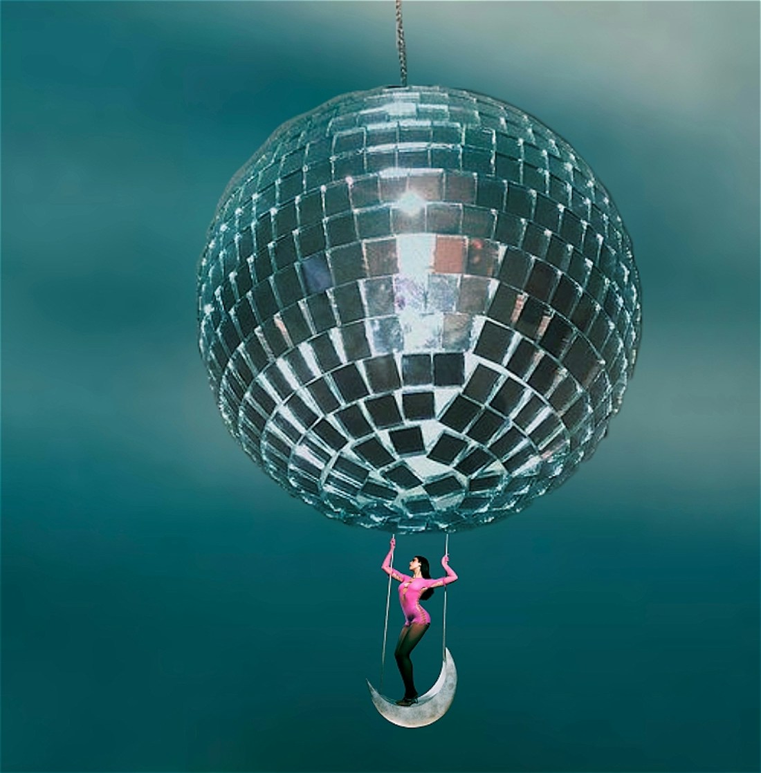 Disco ball with woman in hot pink jumpsuit hanging from it, ocean blue ombre backdrop.