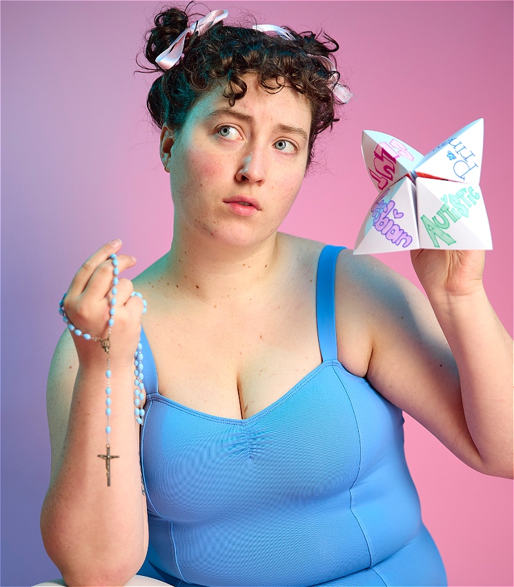 Person in a blue leotard, holds sky blue coloured rosary beads and an origami chatterbox that says in a big font - lesbian in purple, autistic in green, slut in pink and princess in blue.