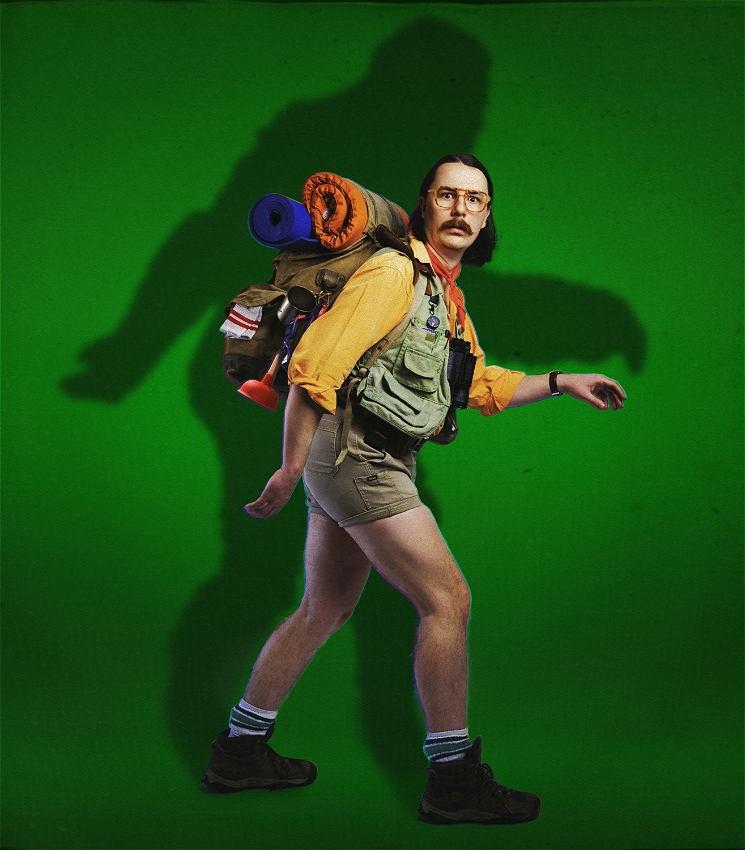 Man in camping gear including large vintage backpack, plunger, fishing vest, short shorts and boots mid-step casting a large shadow the shape of Bigfoot on a green backdrop. Treated to look like the cover of a 70s science fiction novel.
