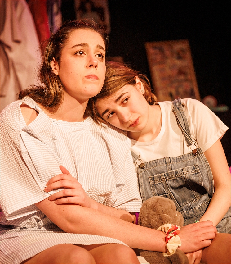 Bridget Morrison and Harper Elwyn who play Emma and Young Emma sitting together with a somber expression.